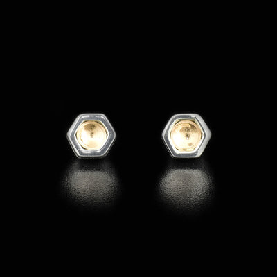 Each stud is a sterling silver hexagon with a concaved, round piece of 14K gold inside. Meant to look like honey-filled hexagons from a honeycomb.