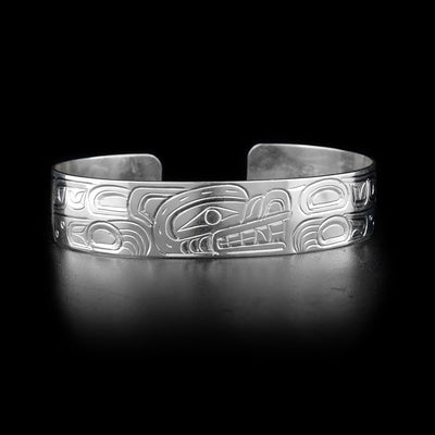 Bracelet with bear head facing left on front and body on sides. Hand-carved by Kwakwaka’wakw artist William Cook.