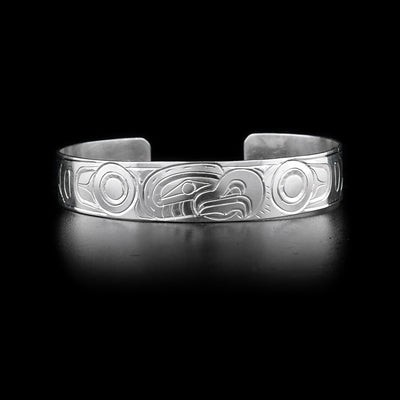 Bracelet with eagle head facing left on front and body on sides. Hand-carved by Kwakwaka’wakw artist William Cook.