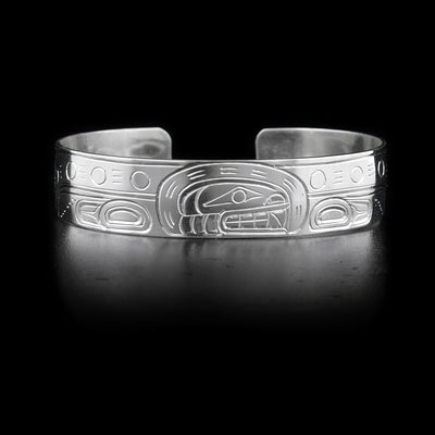 Bracelet with orca head facing left on front and body on sides. Hand-carved by Kwakwaka’wakw artist William Cook.