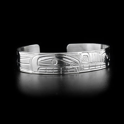 Bracelet depicts orca and wolf snout to snout. Orca on right side. Cross-hatching background. Hand-carved by Heiltsuk artist Reg Gladstone.