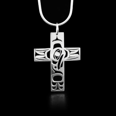 This eagle pendant is in the shape of a cross with a cut out eagle's head in the center of the cross facing down. Intricate designs have been carved around it on all sides.