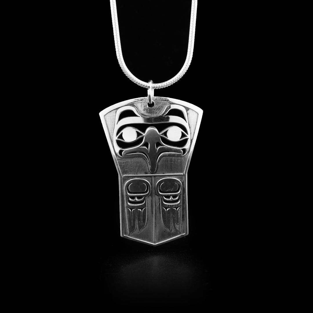 This eagle pendant is in the shape of a shield. It has the head of the eagle facing forward at the top with both its wings carved underneath.