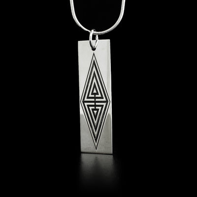 This raven pendant is a rectangular shape with oxidized parts in the shape of a large diamond in the center.