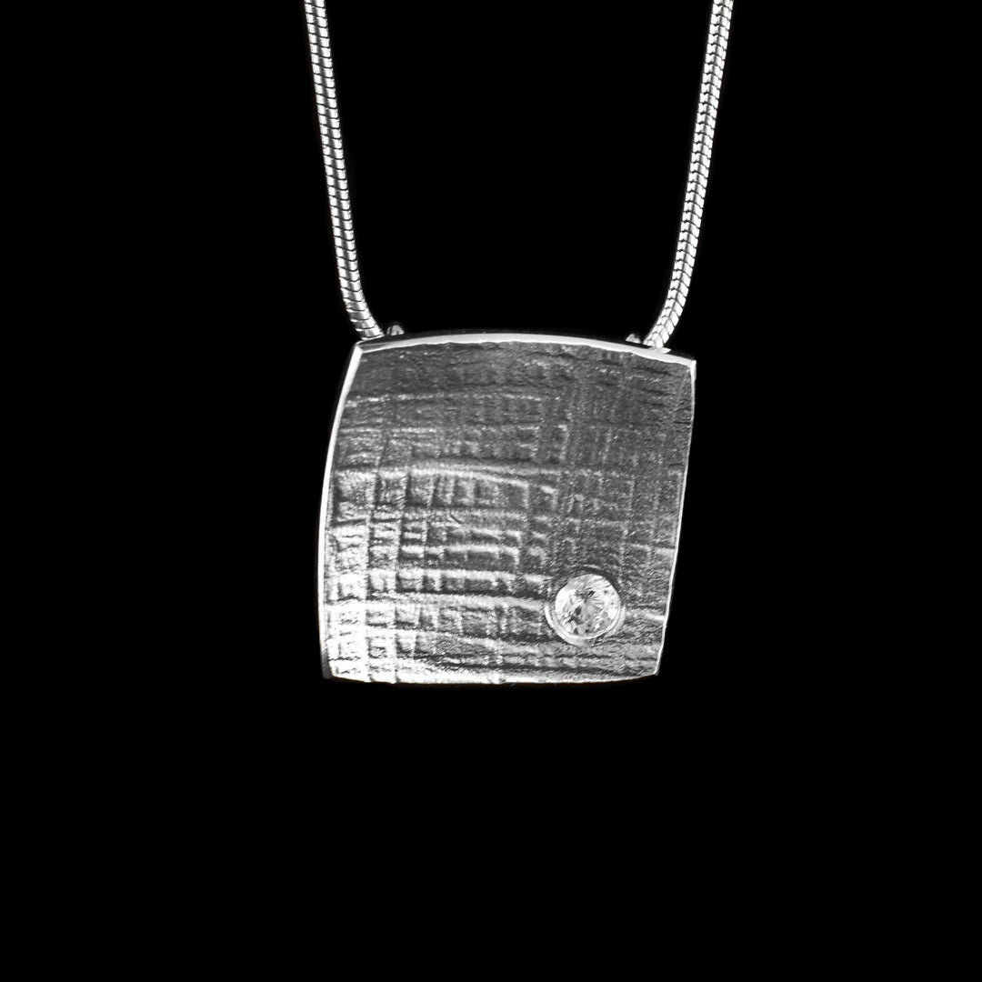 Silver Square Necklace made with sterling silver and in the bottom a cubic zirconia sits on top of the textured silver.