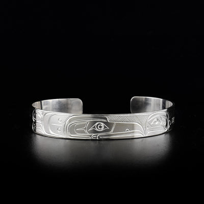 Sterling silver cuff bracelet featuring raven and salmon facing each other.