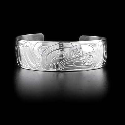 Bracelet with raven head, sun in beak, facing left on front and body on sides. Hand-carved by Kwakwaka’wakw artist William Cook.