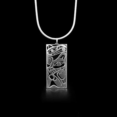 Rectangular pendant featuring wolf and raven. Wolf is facing the left with its paw underneath and raven is right above. Laser-cut, with empty spaces making up design.