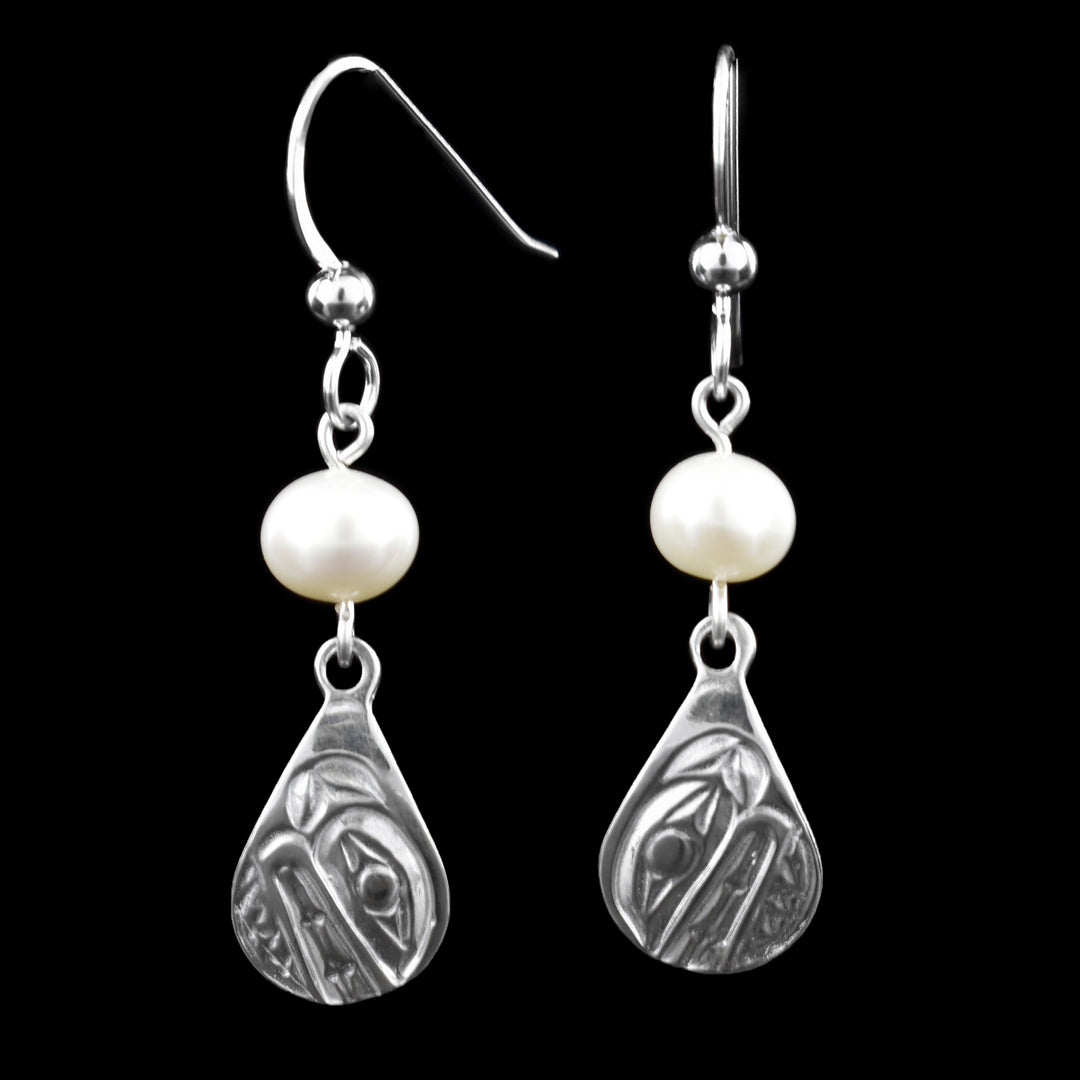 These elegant silver teardrop orca earrings feature engraved orca designs inspired by Northwest Coast art, symbolizing strength and harmony. Each orca earring is accented with a freshwater pearl above the sterling silver orca teardrop design, suspended from classic French hooks.