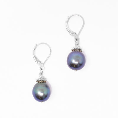 Lever-back earrings with round freshwater pearls. Pearls are framed by adornments on top. Each earring measures 1.31” x 0.38” including hook.