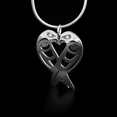 This lovebirds pendant is in the shape of a heart with a bird making up each half of the heart. The birds' heads connect at the top and their tails at the bottom.