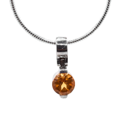 Simple sterling silver pendant with a round, faceted orange citrine. 0.5” long, 0.25” wide. By Ivan Dobren.