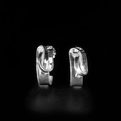 Sterling Silver Overlapping Ribbon Stud Earrings handcrafted by artist Lynda Constantine. Each earring has a width of 0.30" and a diameter of 0.65".