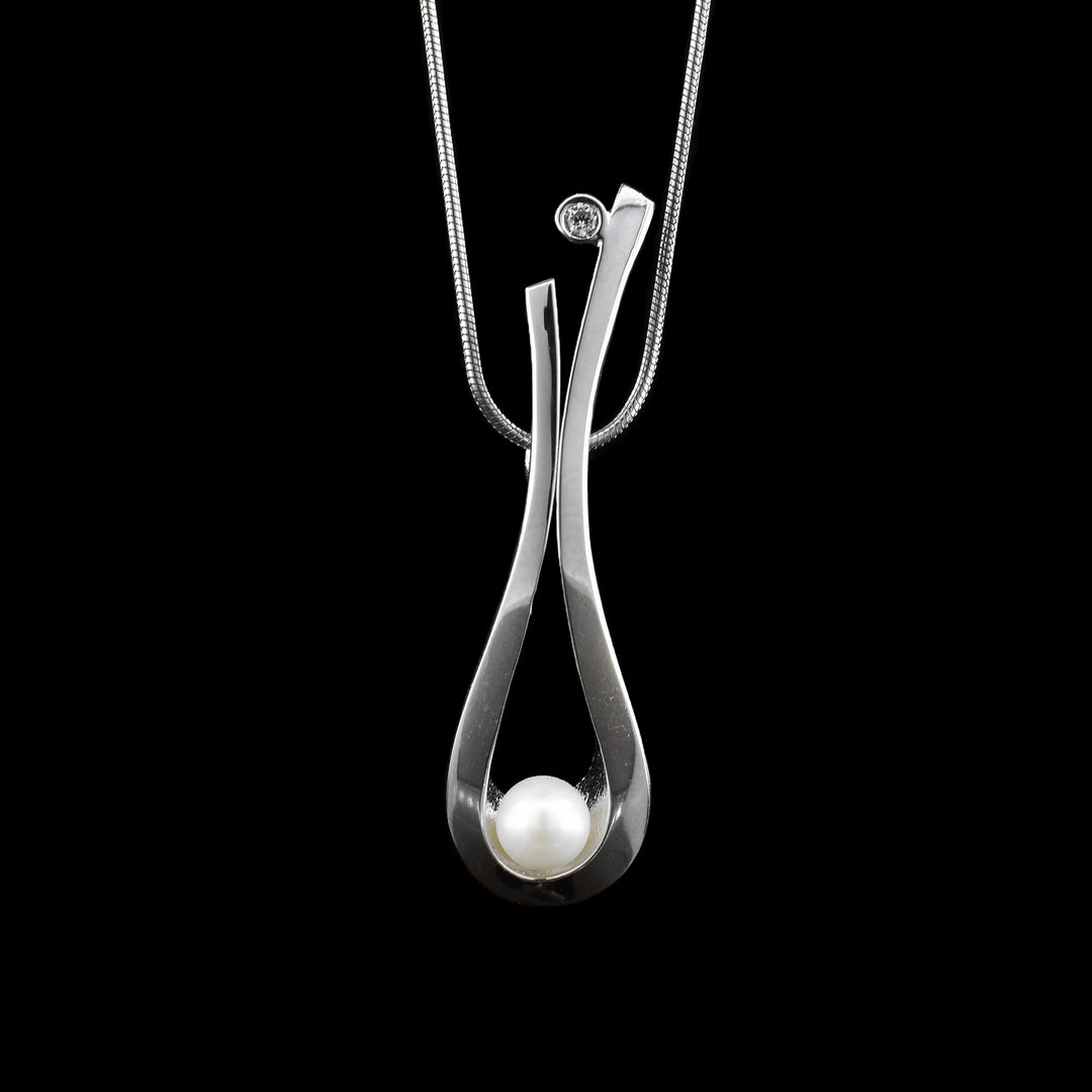 Delicate balance with sterling silver, pearl and cubic zirconia, sterling silver loops down so the pearl sits on the loop. at the end is a round cubic zirconia.