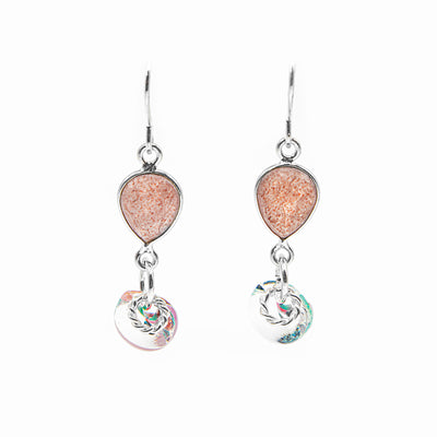 Faceted, downward teardrop-shaped strawberry quartz dangles from hooks. Translucent, colourful glass adornment and silver ring adornment dangle below gemstone. All metal is sterling silver.