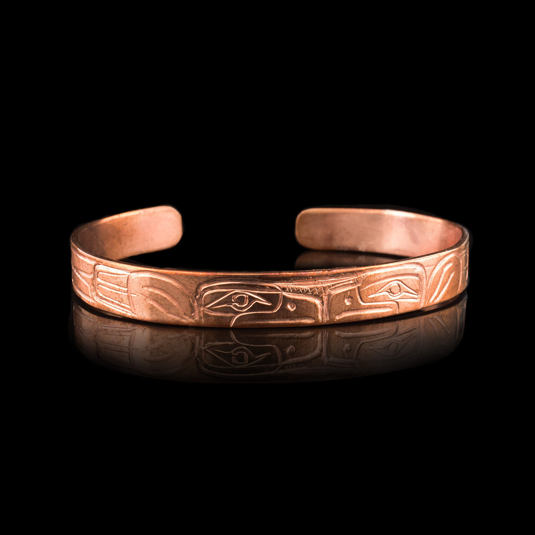 This Thin Copper Double Eagle Cuff Bracelet is hand carved with two eagle heads touching in the middle of the cuff.