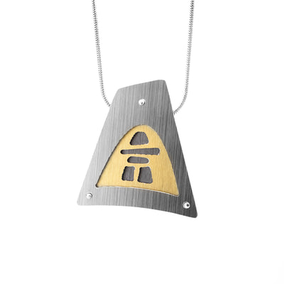 Brushed and anodized aluminum pendant. Large, triangular silver-coloured frame with grey inukshuk inside. Background of inukshuk is gold-coloured. Stainless steel snake chain included.
