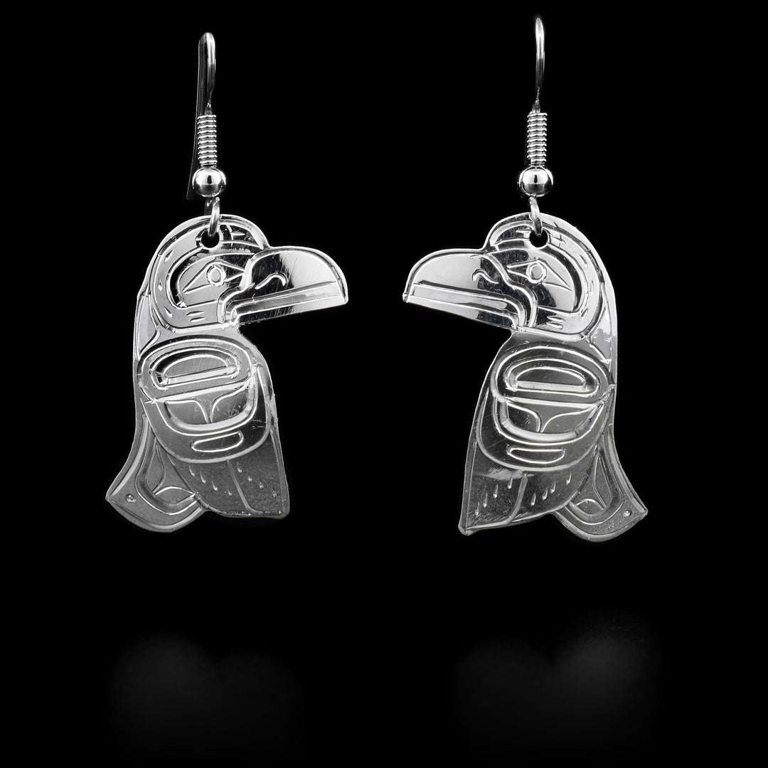 These Raven earrings are made using sterling silver and have Raven shaped hangs. There are carvings made on the surface of the hangs that depict the Raven.