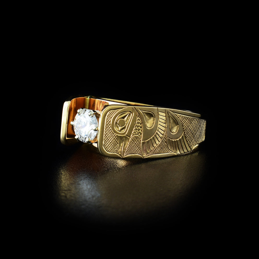 This Cathedral engagement ring has a 14K gold band with a hummingbird carved into both sides of the piece. The legends are in a side profile with their head looking up and wings and tail at the side. The bands extend up and frame the 0.5ct diamond set in the center.