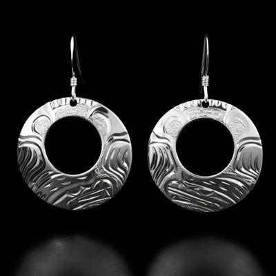 These bear earrings are circular in shape and have a small cut-out hole in the top center. Each earring has the profile of a bear's head and its paws on both sides.