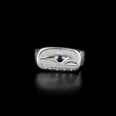 This Sterling Silver Ovoid Signet Orca Ring with Sapphire is hand-carved by Haisla artist, Hollie Bartlett. Hollie has used the technique of crosshatching to depict the face of an orca and has set sapphire in the eye.  Size 7 available.     The Orca Legend Represents: LOGETIVITY, PROTECTION, FAMILY.