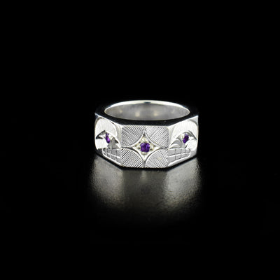 This Sterling Silver Octagonal Orca Ring with Amethyst is hand-carved by Haisla artist, Hollie Bartlett.  She has used crosshatching to depict two orcas facing each other. An amethyst has been set in the center of the ring and in the eye of each orca.  Size 7 available.     The Orca Legend Represents: LONGEVITY, PROTECTION, FAMILY.