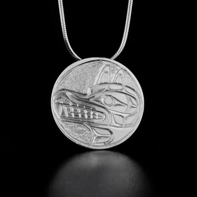 Sterling Silver 1" Round Wolf Pendant by Paddy Seaweed. The design depicts the profile of a wolf's head facing the left with an open mouth. The background has been delicately hand carved to allow for the image of the wolf to stand out.