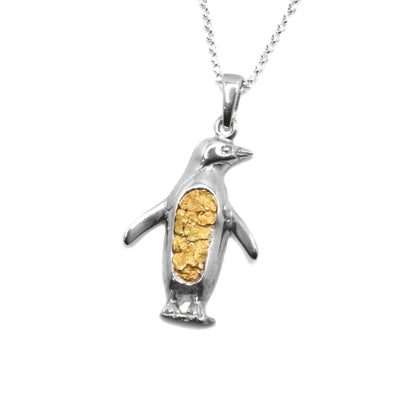 22K Gold Nugget Penguin Pendant by Tom Gregorczyk. The pendant is in the shape of a full-body penguin looking to the right. The 22K Gold Nuggets have been put in the belly of the penguin in an oval shape with the rest of the pendant made out of sterling silver.