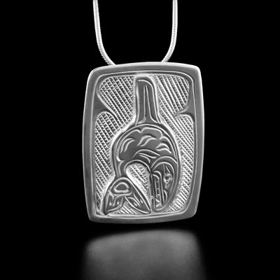 Sterling Silver Rectangular Orca Pendant by Victoria Harper. The artist has hand-carved an orca as if mid-leap in the center of the pendant. The background has been neatly hand-carved in a crisscross pattern to allow for the orca to stand out.