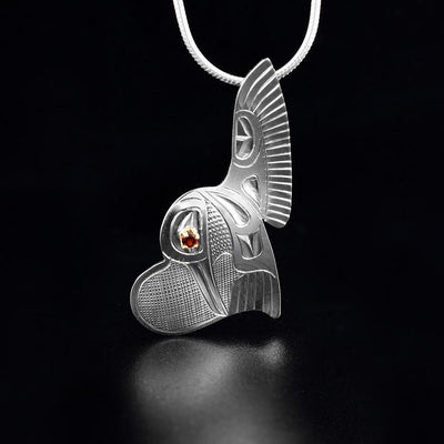 winged heart hummingbird pendant with the garnet eye is hand-carved by Fred Myra