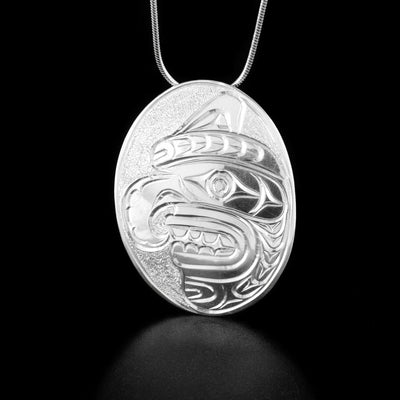 Sterling Silver 2" Wildman Pendant by Paddy Seaweed. The design depicts the profile of a Buk'wus, also known as a Wildman, mask with snarling teeth and a large, pointy nose. facing the left.