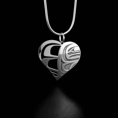 This orca pendant is shaped like a heart with one half having intricate designs and the other neatly created to replicate an orca's face.
