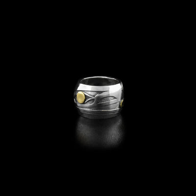 Sterling Silver and 18K Gold Raven Bead by Grant Pauls. The design depicts the profile of a raven's head facing the right. 18K gold has been used for both the raven's eye and for the small ball it is holding in its beak.