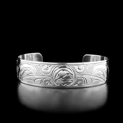 The front of this cuff bracelet has the face of the moon in the center with two hummingbird heads pointing towards it on both sides.