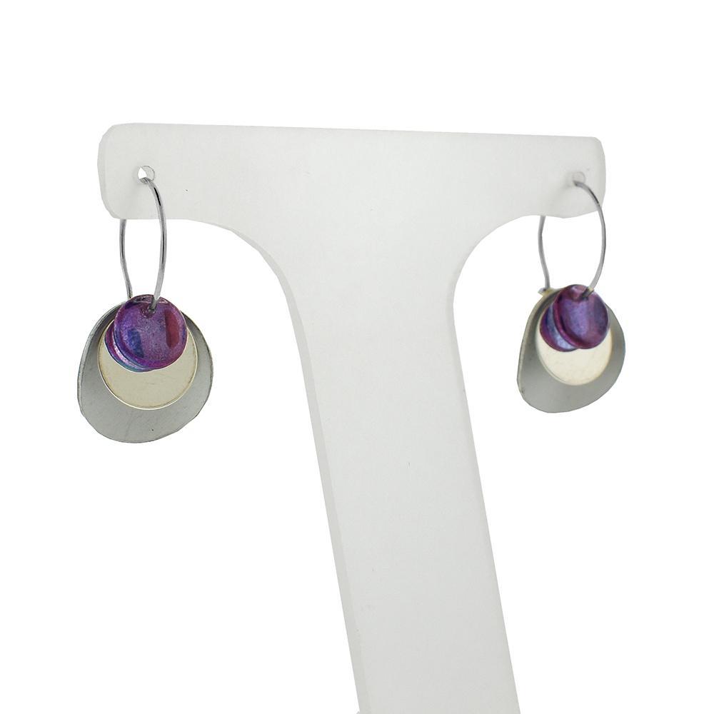 These beaded hoop earrings are made from sterling silver and glass beads. The silver hoops curve below the ear and you can interchangeably add up to three colorful beads to each earring