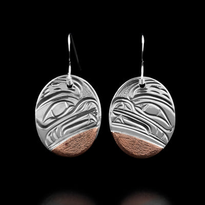 These round earrings have the profile of a bear's head with teeth showing in each earring. There are copper accents at the bottom.