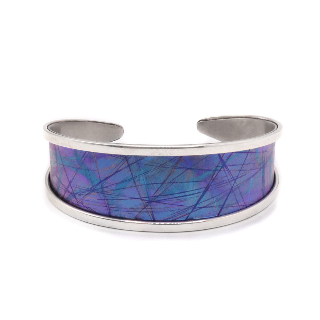 Blue Titanium Tapering Bracelet handmade by Jean-Yves Nantel. Sterling silver accents on top and bottom of the bracelet with blue titanium in the center. Bracelet tapers off in the back.