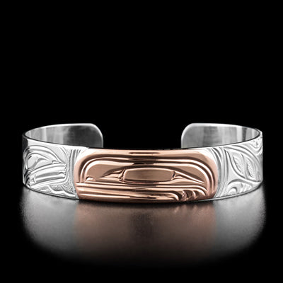 This orca bracelet has the profile of an orca's head made out of copper in the center of the bracelet, facing the left.