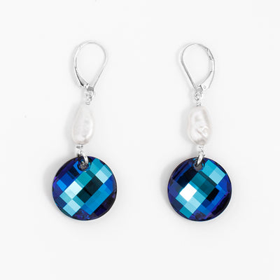 Stunning lever back earrings handcrafted by artist Debra Nelson. Made of sterling silver, Bermuda Blue Swarovski Crystal and freshwater pearls. Each earring measures 2" x 0.67" including hook.