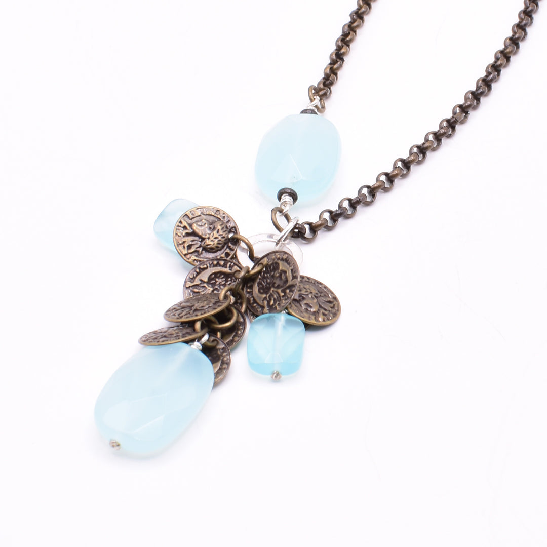 Unique Blue Glass and Antique Brass Coins Pendant Necklace handcrafted by artist Karley Smith. Pendant made of antique brass, blue glass and sterling silver. Chain is antique brass and features an oval glass bead identical to main bead on pendant. Pendant measures 1.85" x 0.50" including bail and chain is 30" long.