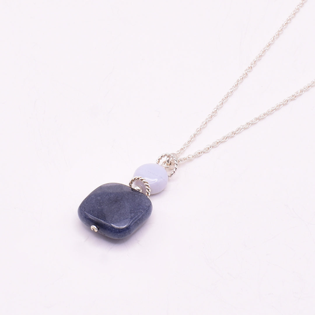 Blue Jade and Blue Lace Agate Pendant Necklace handcrafted by artist Karley Smith. Pendant made of sterling silver, blue jade and blue lace agate. Sterling silver chain included. Pendant measures 1.20" x 0.60" including bail and chain is 18" long.