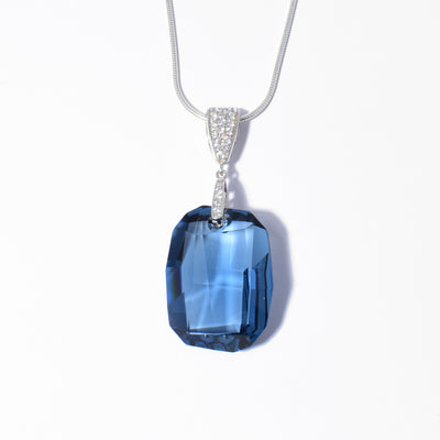 Dazzling Swarovski Crystal pendant handcrafted by artist Debra Nelson. She used a dark blue Swarovski Crystal for the pendant. The sterling silver bail is covered in cubic zirconias. Pendant measures 1.9" x 0.8" including bail. Chain not included.