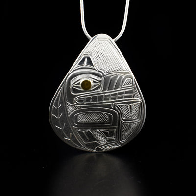 Teardrop wolf pendant hand-carved by Heiltsuk artist Reg Gladstone. Made of 14K gold and sterling silver. Pendant measures 2" x 1.5". Hidden bail on back. Chain not included.