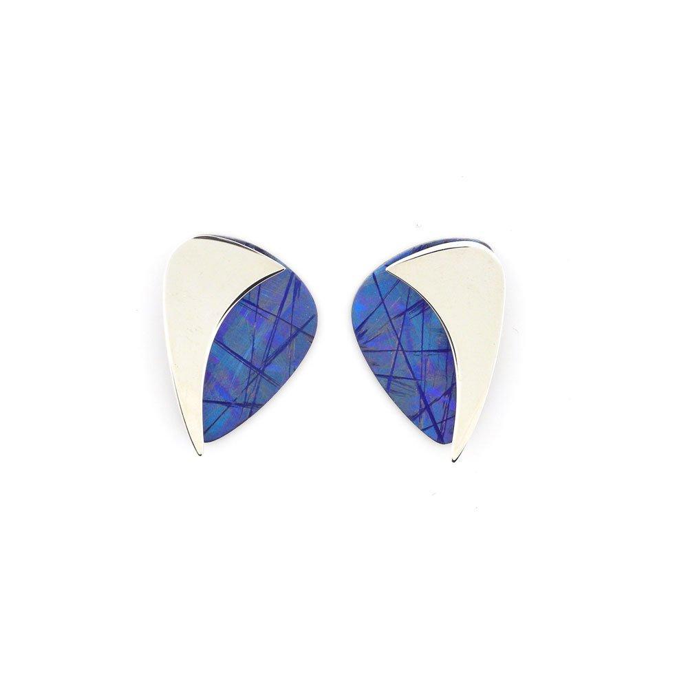 These sterling silver and titanium earrings are oval shaped and are half silver, half anodized titanium. The blue color and designs in the titanium are achieved by anodizing the metal.