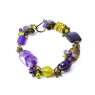 Mystic Bracelet by Honica. Made of serpentine jade, Austrian crystal, freshwater pearls, yellow turquoise, purple goldstone, amethyst, peridot, glass, resins and antique brass.