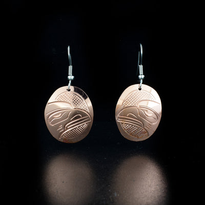 Oval Copper Raven Earrings hand-carved by Kwakwaka'wakw artist John Lancaster. They are made of copper and have sterling silver ear hooks. Each earring measures 1.65" x 0.80" including hook.