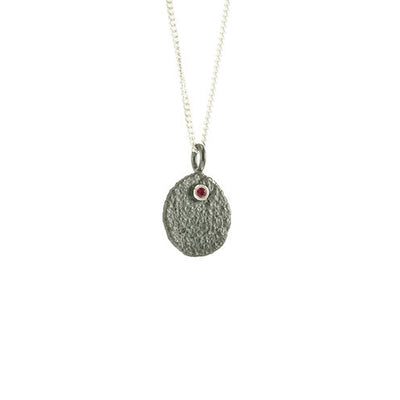 Unique necklace handcrafted by artist Dushka Vujovic. She has used oxidized sterling silver and ruby to create the pendant. Sterling silver chain is included. Pendant measures approximately 0.75" x 0.50" including bail. Chain is 18" long.