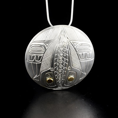 Round domed hummingbird pendant hand-carved by Heiltsuk artist Reg Gladstone. Made of 14K gold and sterling silver. Pendant is 2" in diameter. Hidden bail on back. Chain not included.