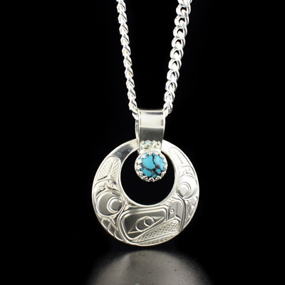 Round Eagle Cut Out Pendant with Turquoise hand-carved by Cree and Coast Salish artist Richard Lang. Made of sterling silver and turquoise. Pendant measures 1.50" x 1.19" including bail. Chain not included.