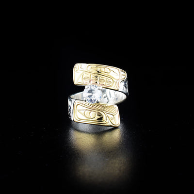 Eagle and wolf wrap ring hand-carved by Coast Salish and Cree artist Richard Lang. Made of sterling silver, 14K gold and a white sapphire. Band is 0.31" wide, with the flexible wrap design giving the ring a comfortable fit. Size 8.5.